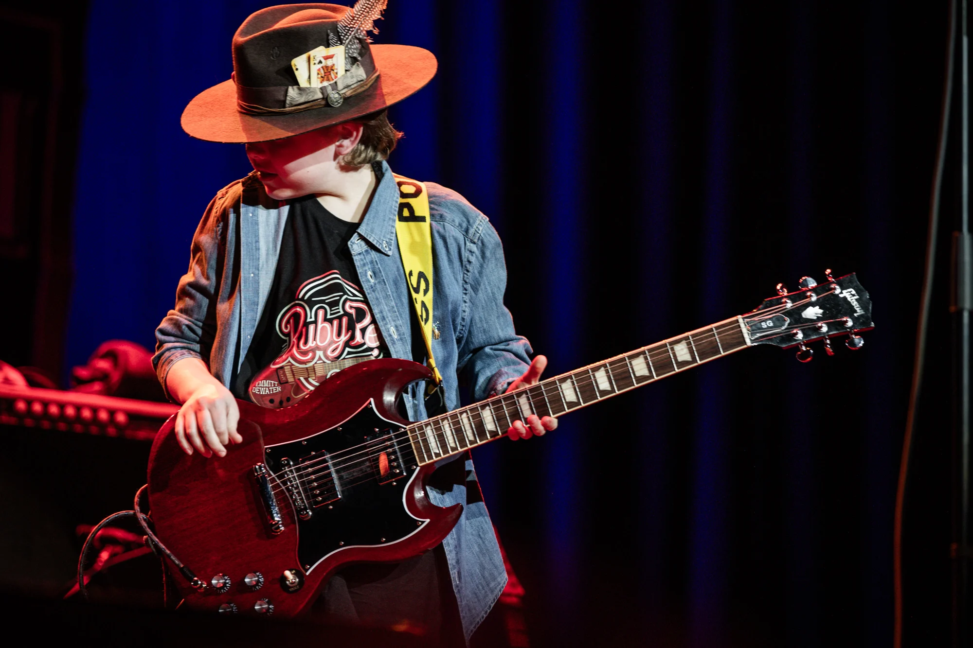 Emmitt DeWater with his red Gibson SG under red and blue stage lights
