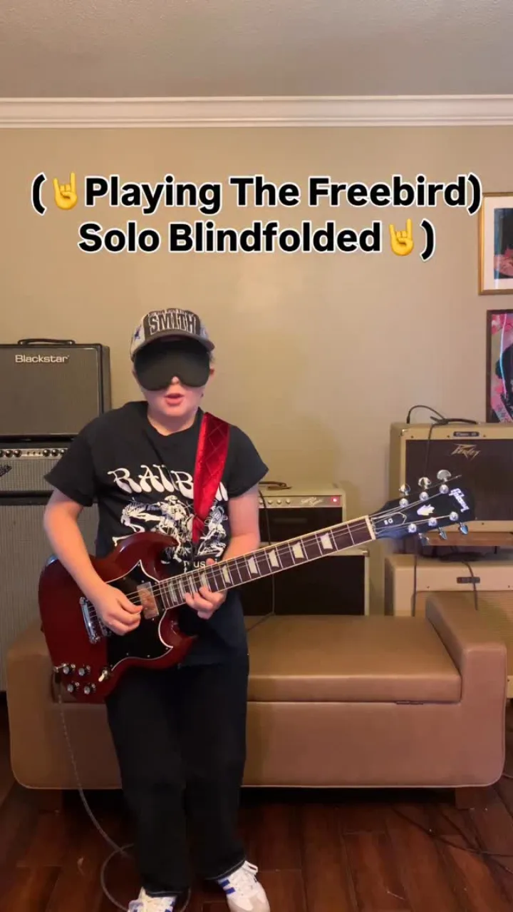 Emmitt DeWater playing a red Gibson SG while blindfolded for a Free Bird solo